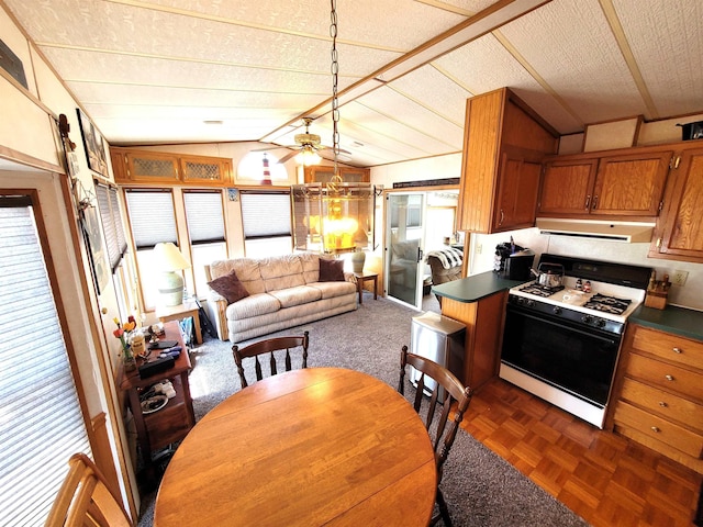 831 S Main St, Au Gres, MI 48703 - kitchen with range with gas stovetop, extractor fan, dark countertops, brown cabinetry, and lofted ceiling