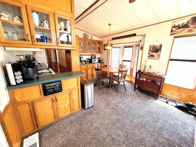 831 S Main St, Au Gres, MI 48703 - kitchen featuring carpet flooring, vaulted ceiling, dark countertops, glass insert cabinets, and decorative light fixtures