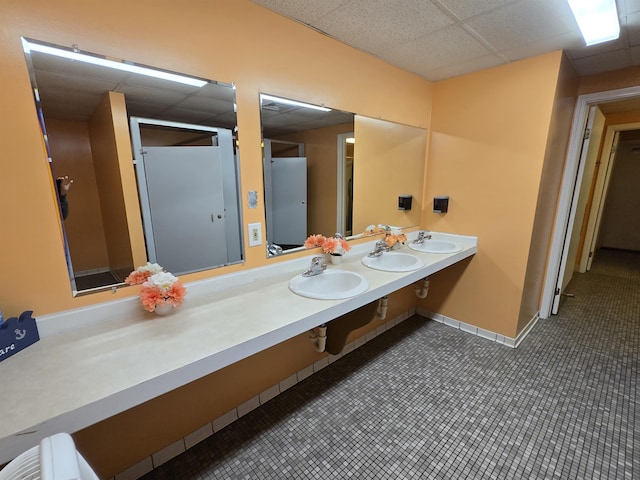 831 S Main St, Au Gres, MI 48703 - full bathroom featuring a paneled ceiling, double vanity, baseboards, and tile patterned floors