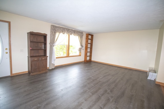 unfurnished living room with dark wood-type flooring