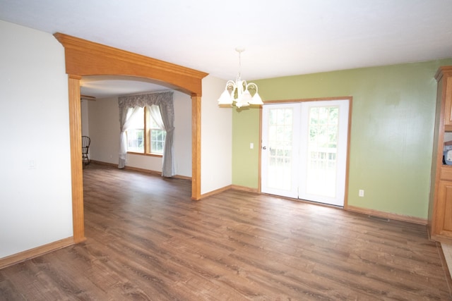 spare room featuring dark hardwood / wood-style floors and an inviting chandelier