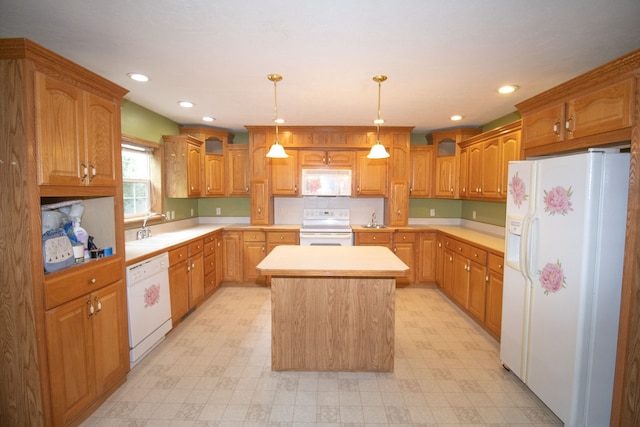 kitchen with a kitchen island, white appliances, sink, and hanging light fixtures