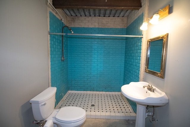 bathroom featuring toilet and a tile shower