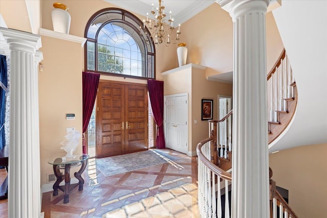 entrance foyer with a high ceiling, ornamental molding, and a notable chandelier