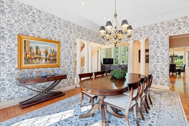 dining space with light wood-type flooring, ornate columns, and a wealth of natural light