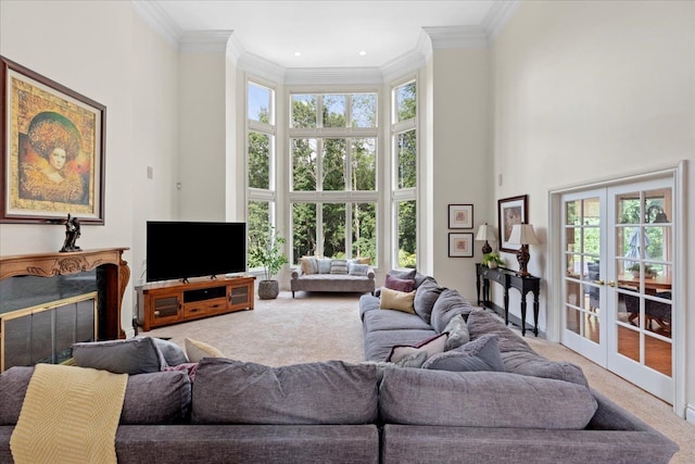 carpeted living room with a towering ceiling, crown molding, and a wealth of natural light