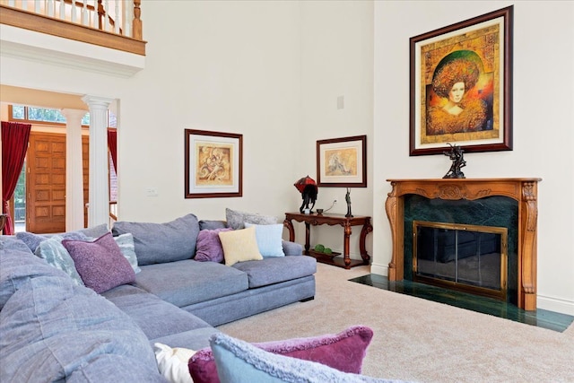 carpeted living room with decorative columns and a premium fireplace