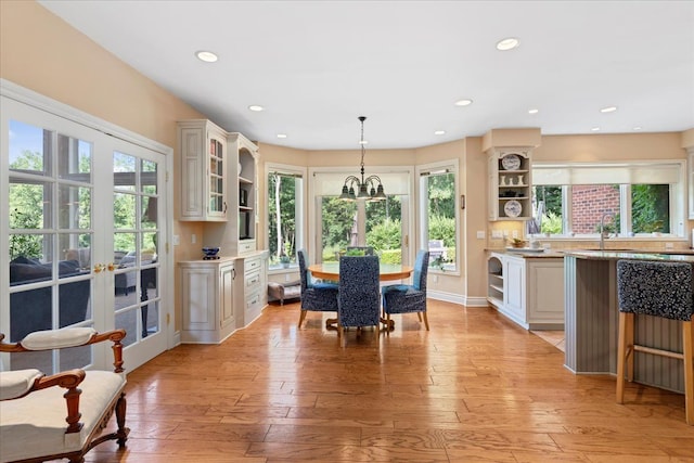 dining room featuring a chandelier, french doors, light hardwood / wood-style floors, and sink