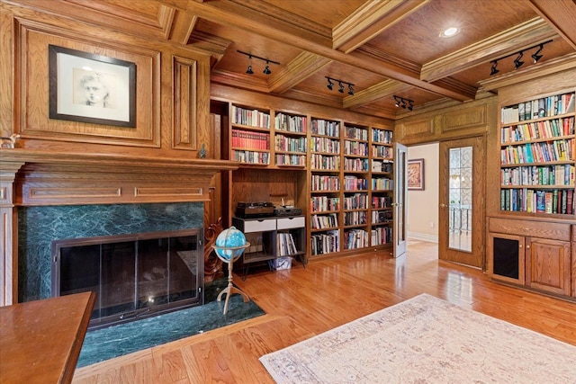 sitting room featuring built in shelves, wooden ceiling, coffered ceiling, crown molding, and a fireplace