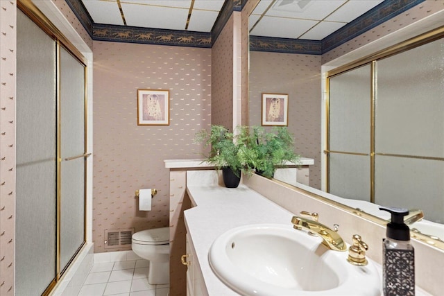 bathroom with tile patterned flooring, toilet, an enclosed shower, and vanity