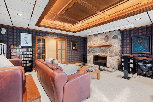 carpeted living room featuring wooden ceiling, coffered ceiling, french doors, ornamental molding, and a fireplace