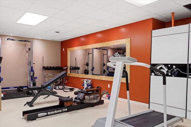 exercise area featuring carpet flooring and a drop ceiling