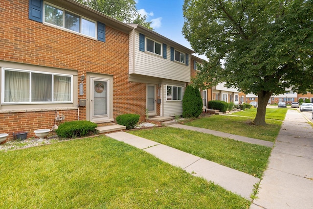 townhome / multi-family property featuring a front lawn