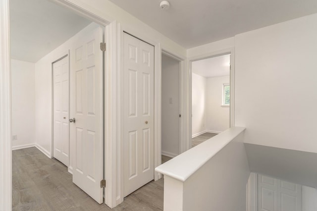 corridor with light hardwood / wood-style floors