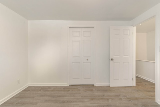 unfurnished bedroom featuring a closet and light hardwood / wood-style flooring