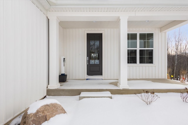 snow covered property entrance with board and batten siding