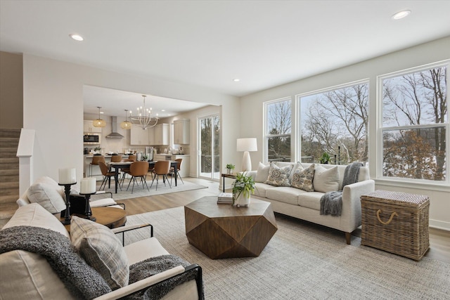 living area featuring a chandelier, recessed lighting, light wood-style flooring, and stairs