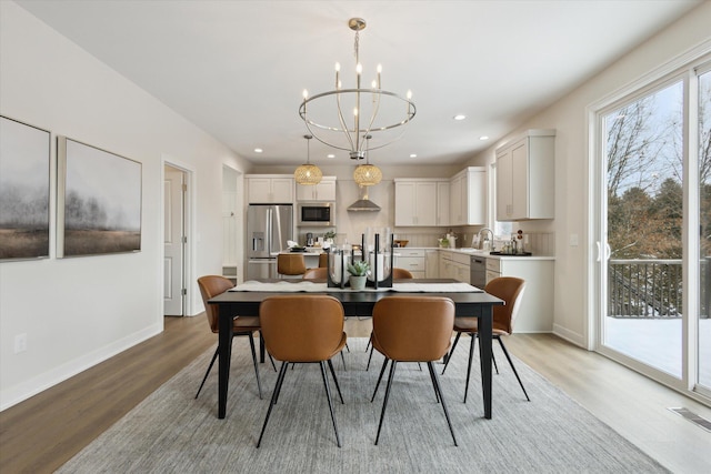 dining room with light wood-style floors, recessed lighting, visible vents, and baseboards