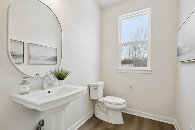 bathroom with a sink, wood finished floors, toilet, and baseboards