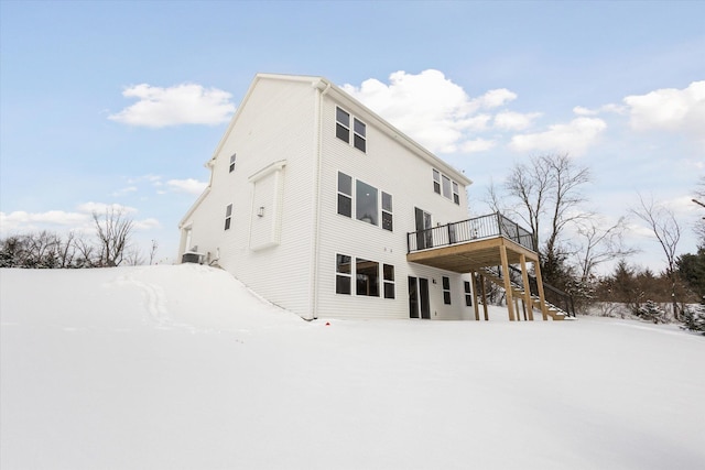 snow covered property featuring central AC unit, stairway, and a deck