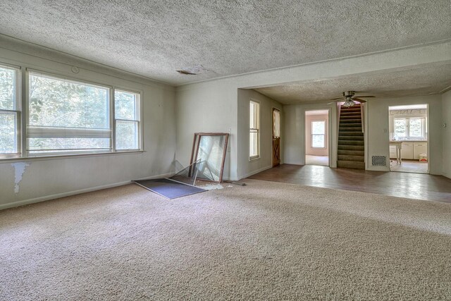 2435 108th Ave, Otsego, MI 49078 - unfurnished living room featuring carpet, a textured ceiling, stairway, baseboards, and a ceiling fan