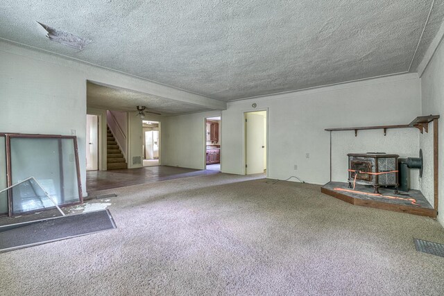 2435 108th Ave, Otsego, MI 49078 - unfurnished living room with a wood stove, a textured ceiling, stairway, and carpet flooring