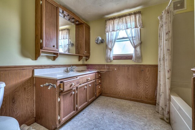2435 108th Ave, Otsego, MI 49078 - full bath featuring wainscoting, vanity, wooden walls, toilet, and shower / tub combo with curtain