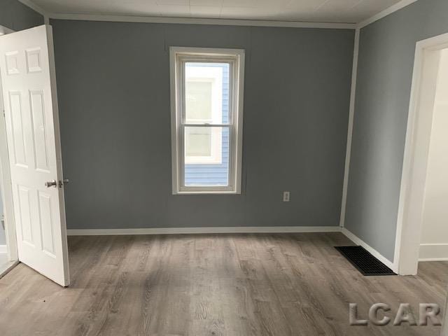 551 Tabor St, Adrian, MI 49221 - spare room with ornamental molding, wood finished floors, and baseboards