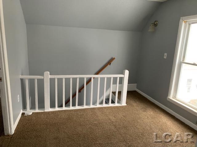 551 Tabor St, Adrian, MI 49221 - stairs featuring carpet, vaulted ceiling, and baseboards
