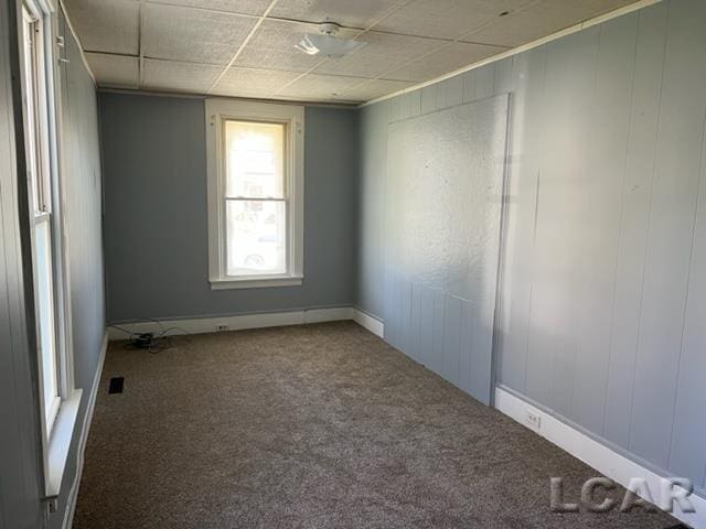 carpeted empty room with a paneled ceiling