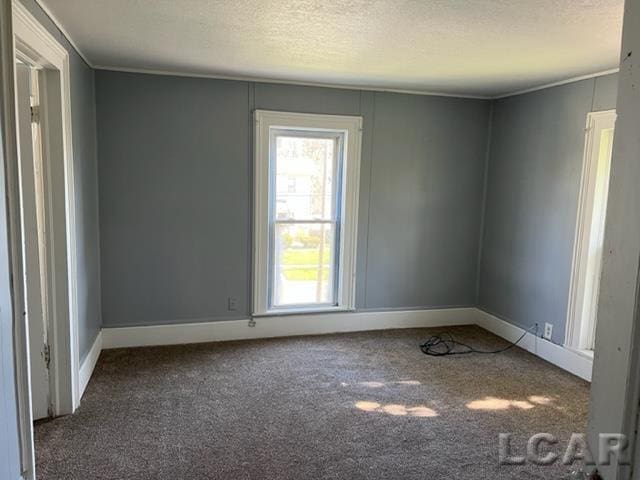 carpeted spare room with a textured ceiling