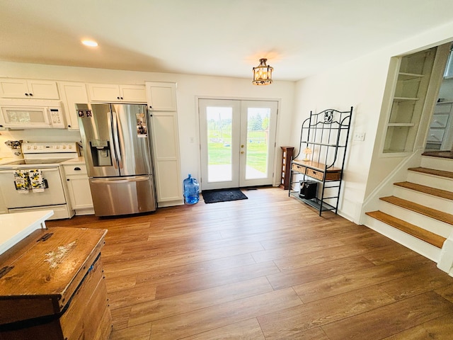 58191 8 Mile Rd, Northville, MI 48167 - kitchen with white appliances, light wood-type flooring, french doors, white cabinetry, and recessed lighting