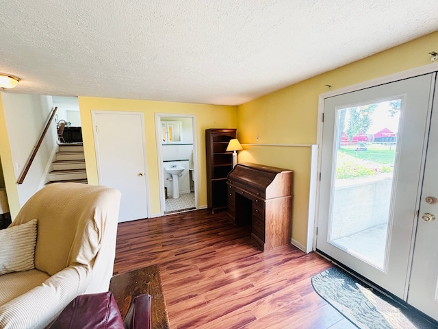 living room featuring hardwood / wood-style floors, a textured ceiling, and sink