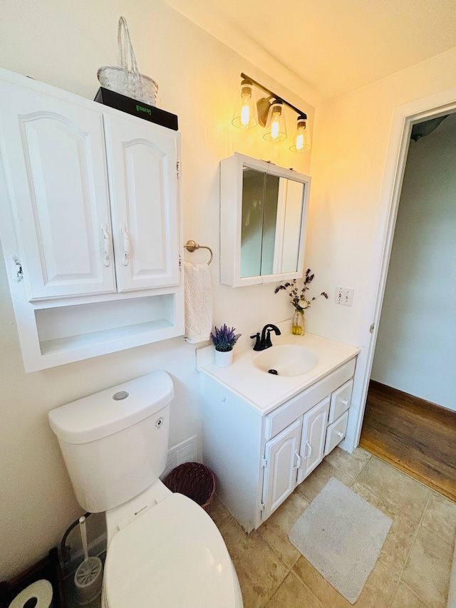 bathroom with wood-type flooring, vanity, and toilet