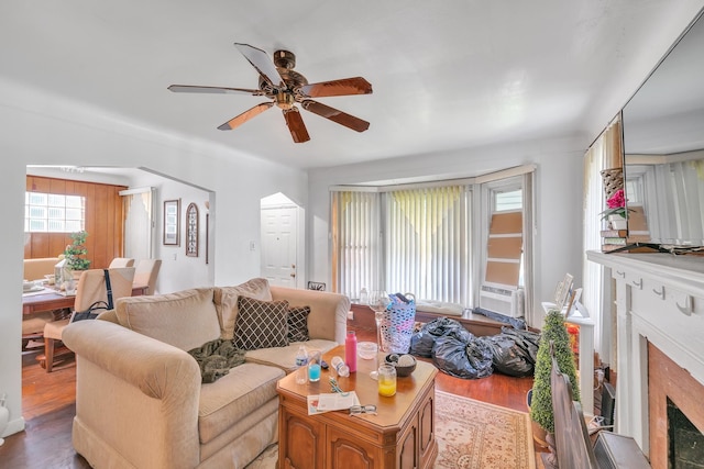 living room featuring hardwood / wood-style flooring, ceiling fan, and a premium fireplace