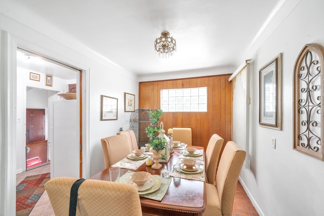 dining space with wood walls and wood-type flooring