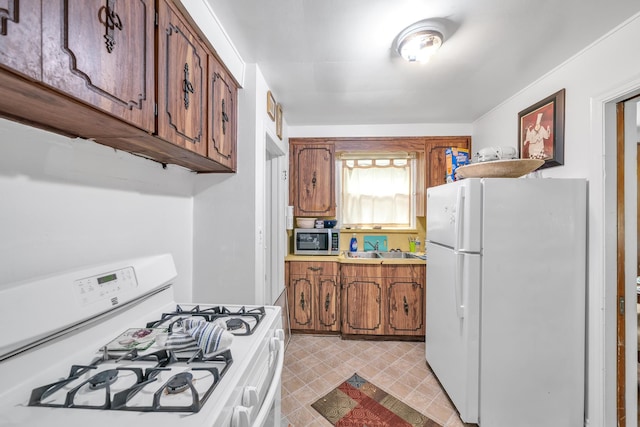 kitchen featuring white appliances and sink