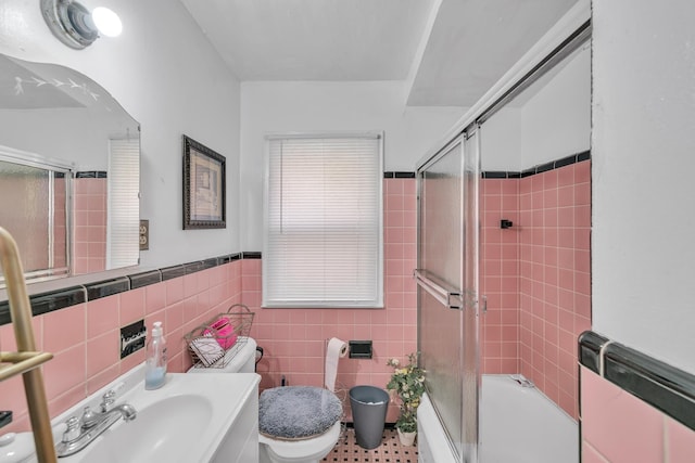 full bathroom with shower / bath combination with glass door, tile walls, and sink