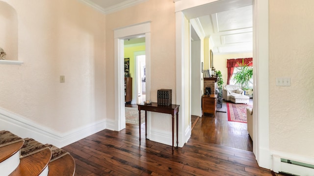 hall with ornamental molding, baseboard heating, and dark wood-type flooring