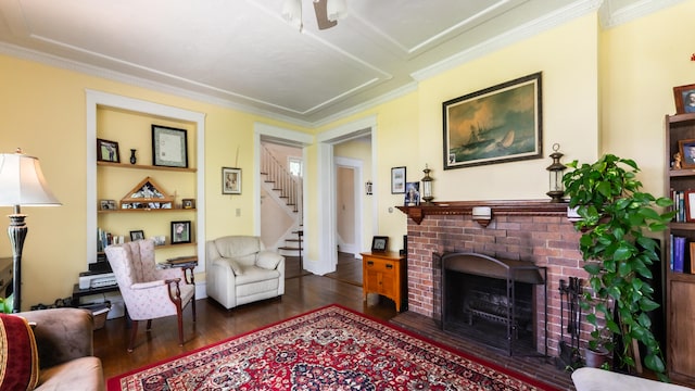 living room featuring a fireplace, crown molding, and dark wood-type flooring