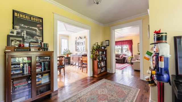 corridor with dark hardwood / wood-style flooring, ornamental molding, and a wealth of natural light