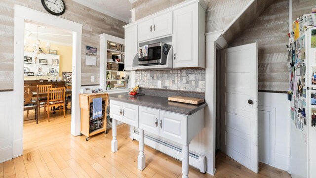 15 S Broad St, Hillsdale, MI 49242 - kitchen with stainless steel microwave, light wood-type flooring, dark countertops, and white cabinets