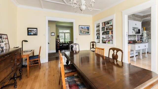 15 S Broad St, Hillsdale, MI 49242 - dining space with ornamental molding, a chandelier, light wood finished floors, baseboard heating, and built in features