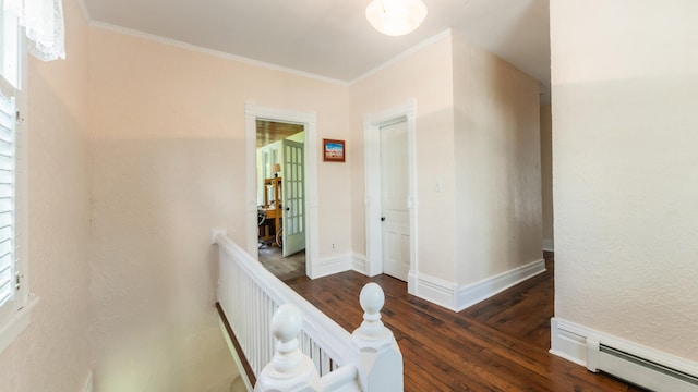 corridor featuring crown molding, dark wood-type flooring, and a baseboard heating unit