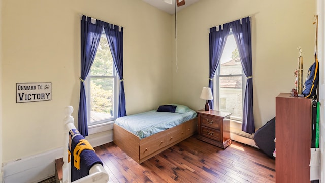 bedroom with hardwood / wood-style floors and multiple windows