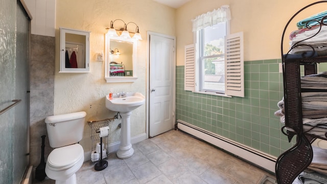 bathroom with tile patterned flooring, a baseboard radiator, tile walls, and toilet