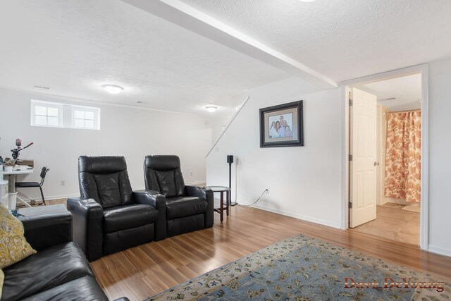 cinema room with a textured ceiling and hardwood / wood-style flooring