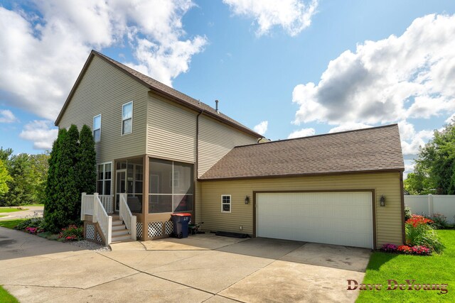 view of front facade with a garage and a sunroom