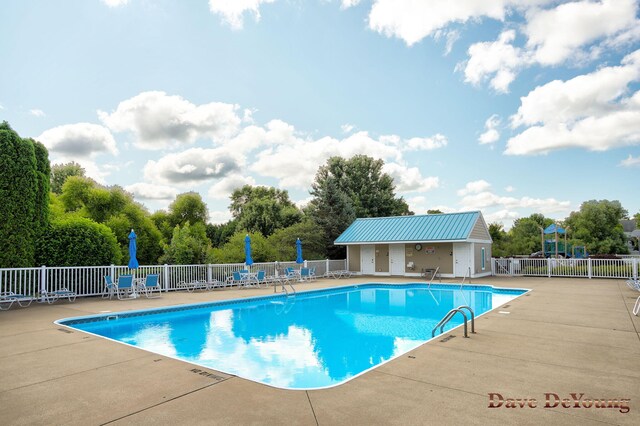 view of pool featuring an outbuilding and a patio