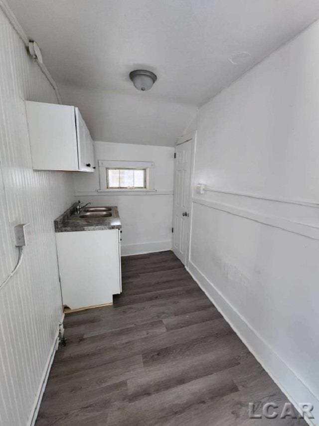 laundry area featuring sink and dark wood-type flooring